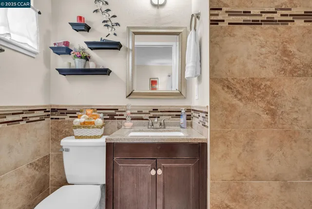 a bathroom with a sink vanity mirror and toilet