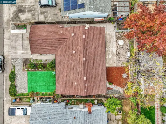 an aerial view of a house with a yard and a large tree