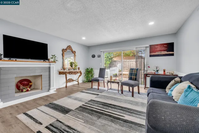 a living room with furniture a fireplace and a flat screen tv