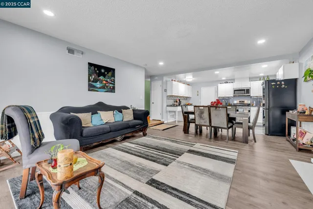 a living room with lots of furniture and kitchen view