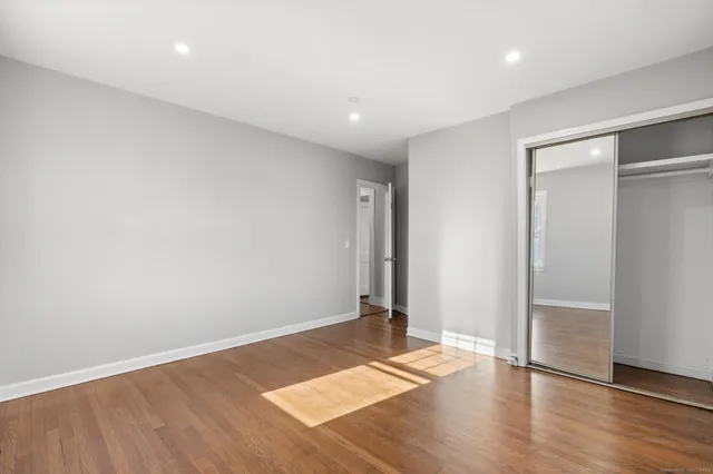 an empty room with wooden floor and entrance