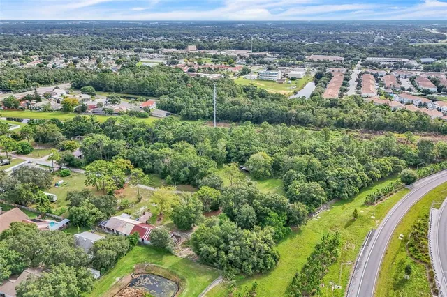 an aerial view of residential houses with outdoor space and trees