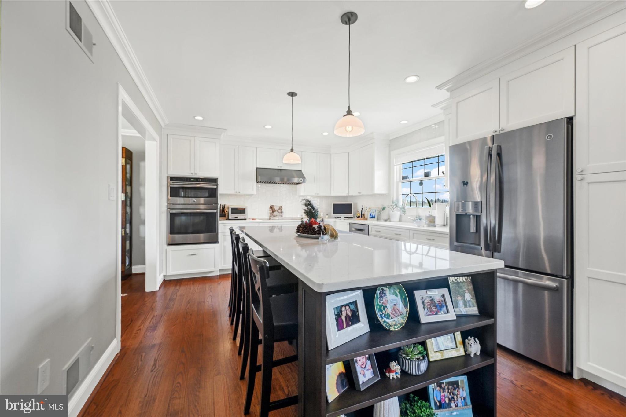 2211 Old Bosley Road Cockeysville, MD 21030 - Photo 15 of 65 a kitchen with stainless steel appliances a dining table chairs refrigerator and microwave