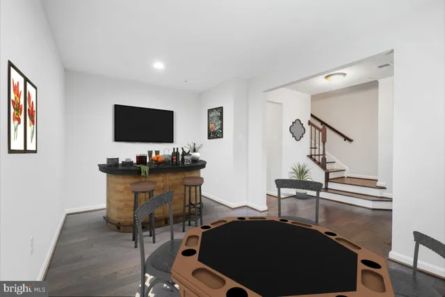 a view of an empty room with wooden floor and stairs