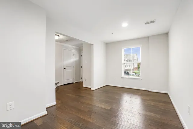a view of a kitchen with kitchen island a island wooden floor stainless steel appliances and a window