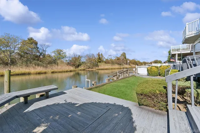 a view of a lake with a yard and large trees