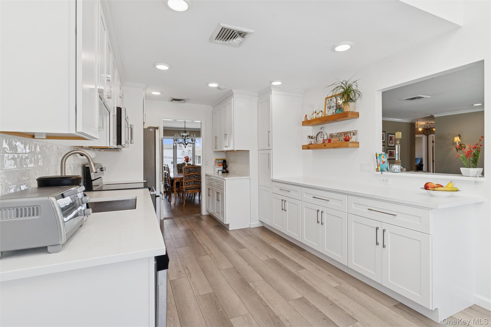2858 Shore Road Bellmore, NY 11710 - Photo 9 of 38 a large kitchen with stainless steel appliances lots of counter top space and wooden floor