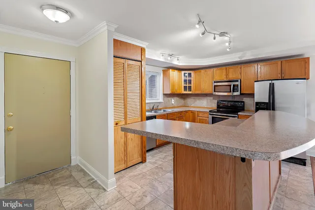 a kitchen with stainless steel appliances granite countertop a sink refrigerator and microwave