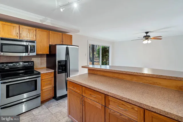a kitchen with stainless steel appliances a stove microwave and refrigerator