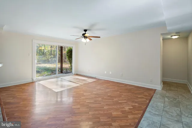 an empty room with wooden floor and window