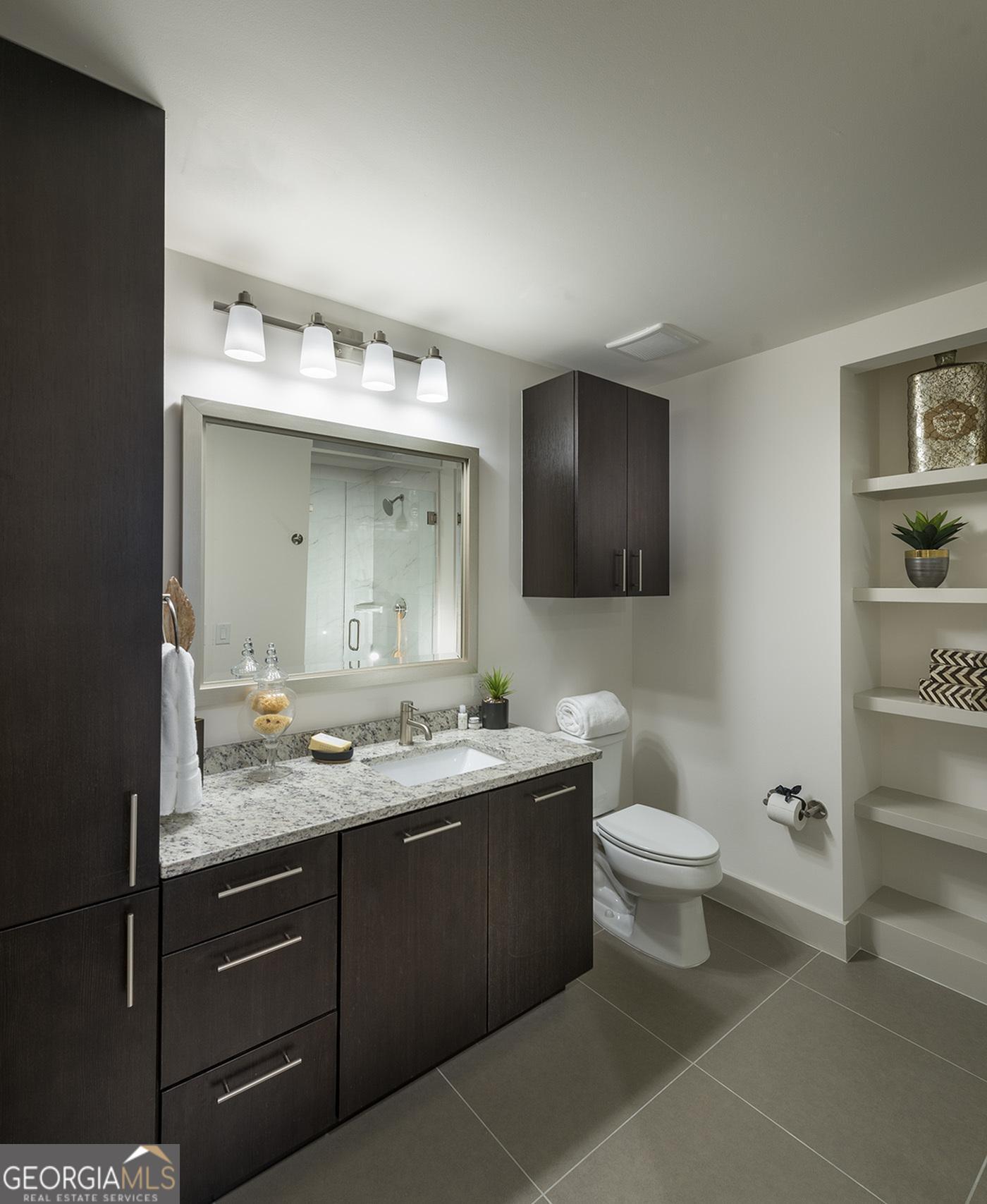 3150 Roswell Road Northwest, Unit 620 Atlanta, GA 30305 - Photo 7 of 26 a bathroom with a toilet sink double vanity and mirror