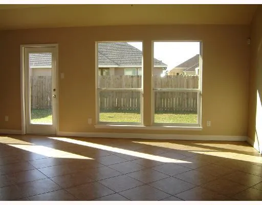 a view of a room with wooden floor and a floor to ceiling window