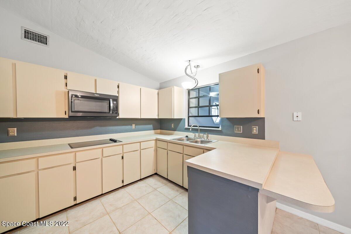 6840 Cairo Road Cocoa, FL 32927 - Photo 6 of 26 a kitchen with granite countertop white cabinets and white appliances