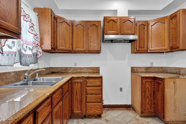 a kitchen with stainless steel appliances granite countertop a refrigerator and wooden cabinets