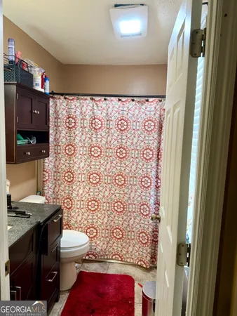 a bathroom with a toilet and a shower curtain