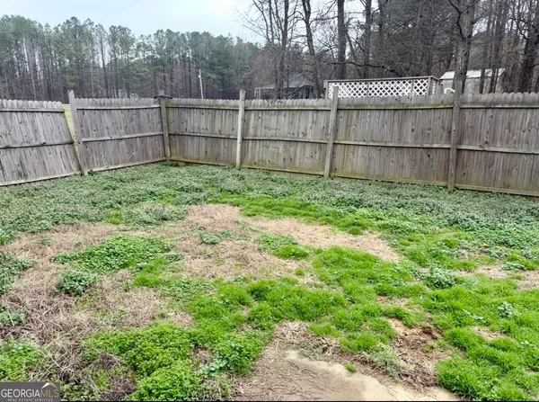 a view of a backyard with wooden fence