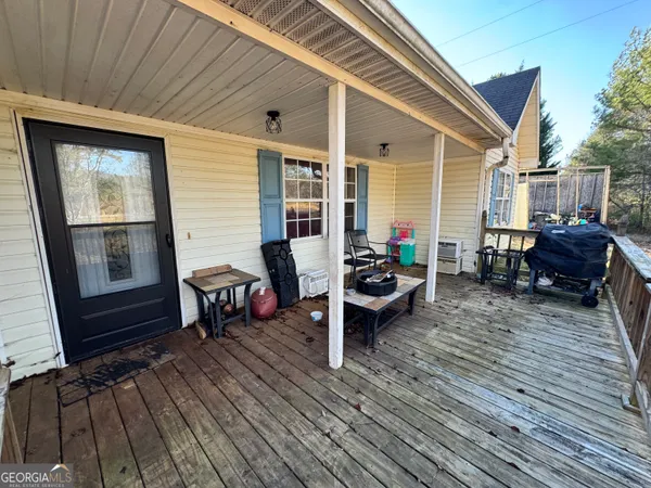 a view of a patio with table and chairs with wooden floor and fence