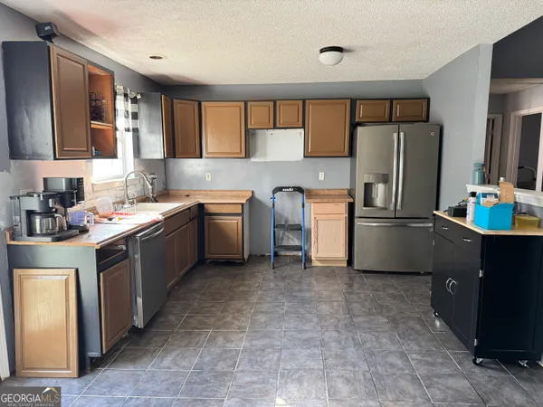 a kitchen with a sink refrigerator and cabinets