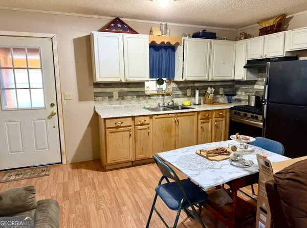 a kitchen with stainless steel appliances granite countertop a kitchen island a stove a table and chairs