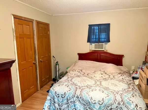 a bedroom with a bed and a lamp on dresser
