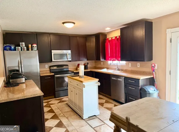 a kitchen with a sink stove and refrigerator