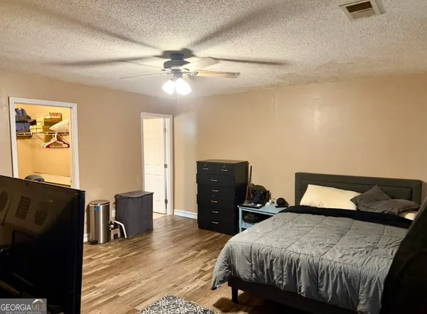 a bedroom with a bed and wooden floor