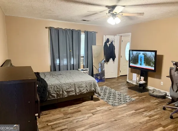 a bedroom with a bed and a mirror on the dresser