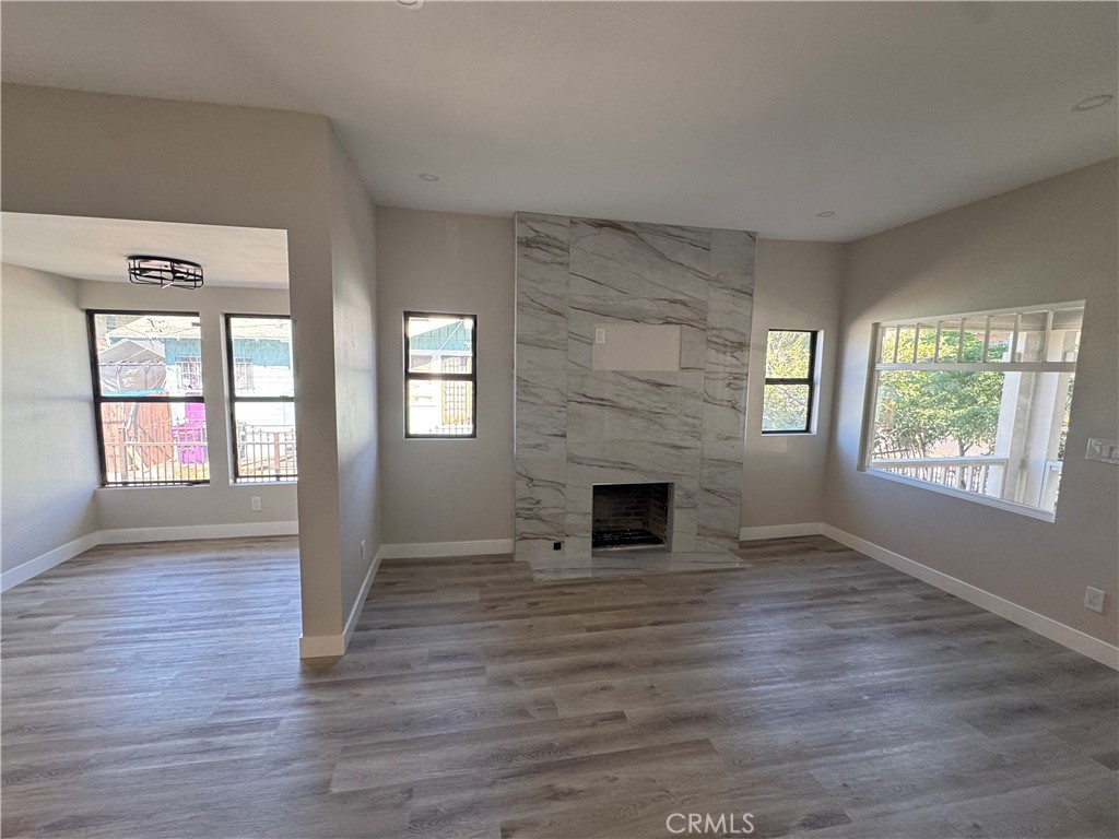 529 West 10th Street Long Beach, CA 90813 - Photo 14 of 19 an empty room with wooden floor fireplace and windows