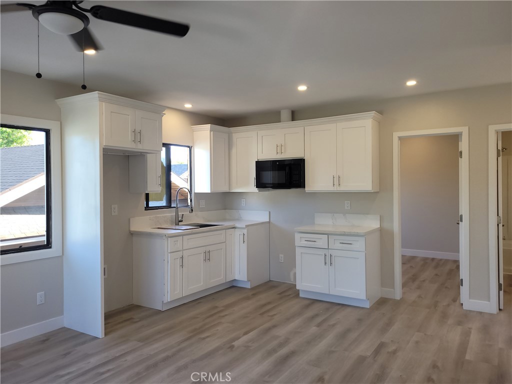 529 West 10th Street Long Beach, CA 90813 - Photo 17 of 19 a kitchen with granite countertop white cabinets and white appliances