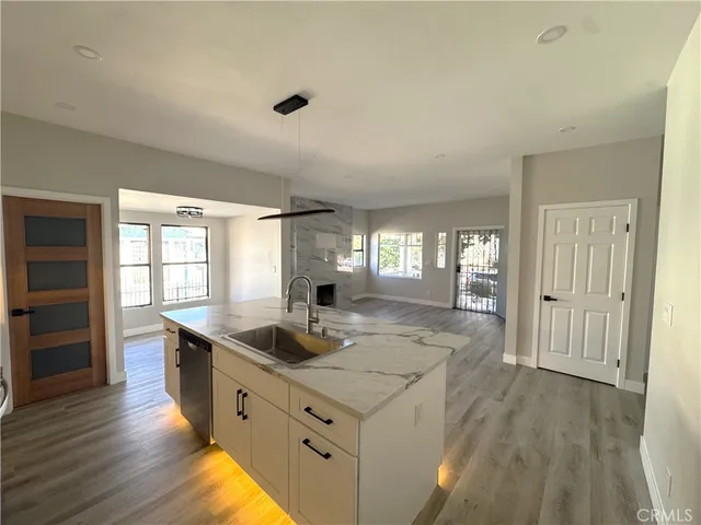 a kitchen with stainless steel appliances granite countertop a sink stove and wooden floor