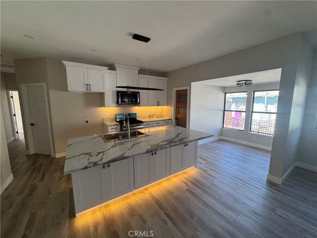 529 West 10th Street Long Beach, CA 90813 - Photo 8 of 19 a kitchen with stainless steel appliances granite countertop a sink stove and wooden floor