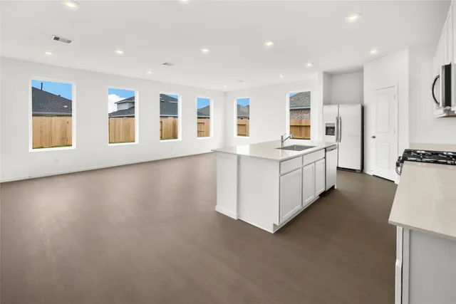 a open kitchen with stainless steel appliances granite countertop a stove and a refrigerator