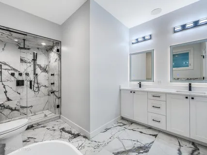 a en suite bathroom with a double vanity sink mirror and shower