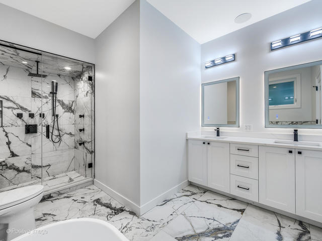 867 North Marshfield Avenue, Unit 1 Chicago, IL 60622 - Photo 11 of 12 a en suite bathroom with a double vanity sink mirror and shower