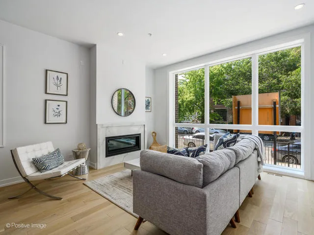 a living room with fireplace furniture and a large window