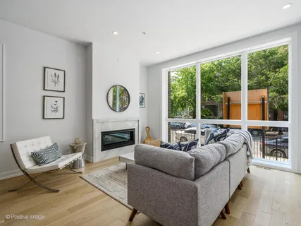 a living room with fireplace furniture and a large window