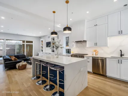 a kitchen with stainless steel appliances granite countertop a sink a stove and a refrigerator