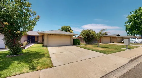 a front view of a house with a yard and a garage