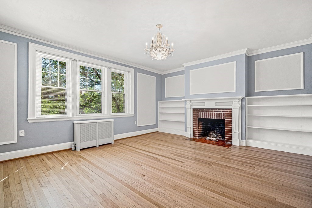 6 Lanark Road, Unit 4 Brookline, MA 02445 - Photo 4 of 23 a view of an empty room with wooden floor fireplace and a window