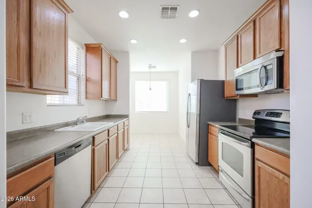 a kitchen with stainless steel appliances granite countertop a stove a refrigerator and a sink
