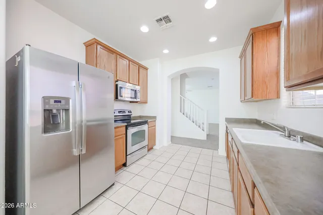 a kitchen with stainless steel appliances granite countertop a refrigerator and a sink