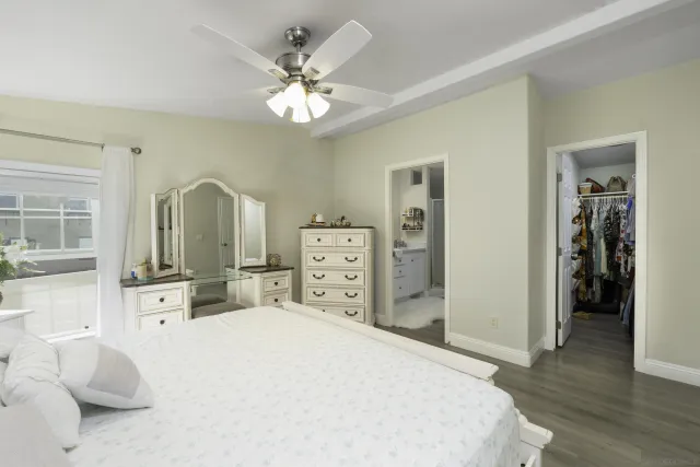 a bedroom with a bed and a large mirror with wooden floor