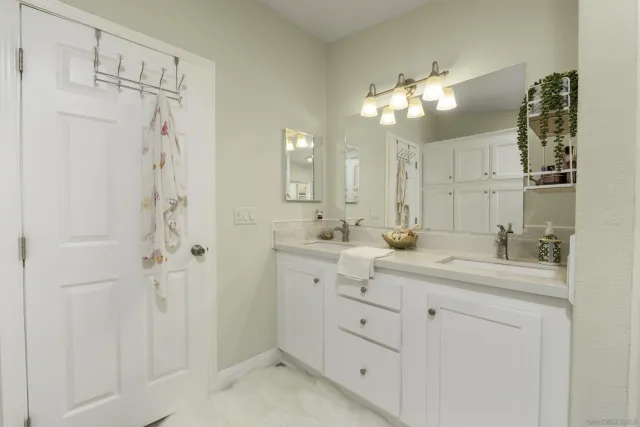 a bathroom with a double vanity sink mirror and shower