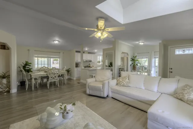 a living room with furniture kitchen view and a dining table