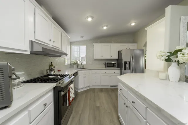 a kitchen that has a sink cabinets counter space and stainless steel appliances