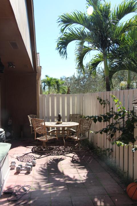 22272 Timberly Drive Boca Raton, FL 33428 - Photo 7 of 7 a view of a patio with table and chairs potted plants with wooden floor