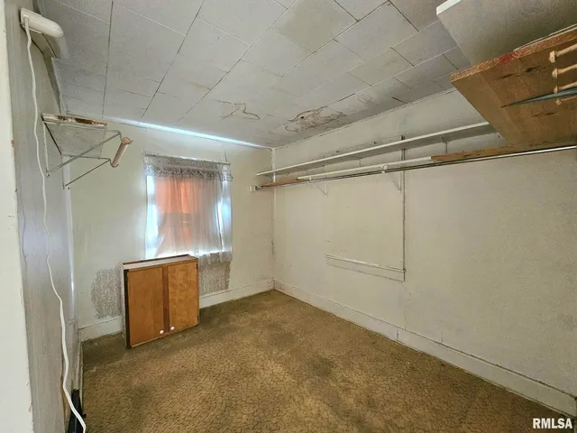 an empty room with windows and closet