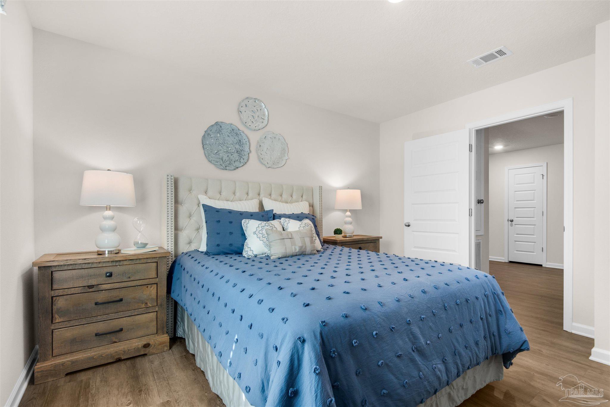 5213 Conservation Circle Pace, FL 32571 - Photo 11 of 13 a bedroom with a bed and closet with mirror