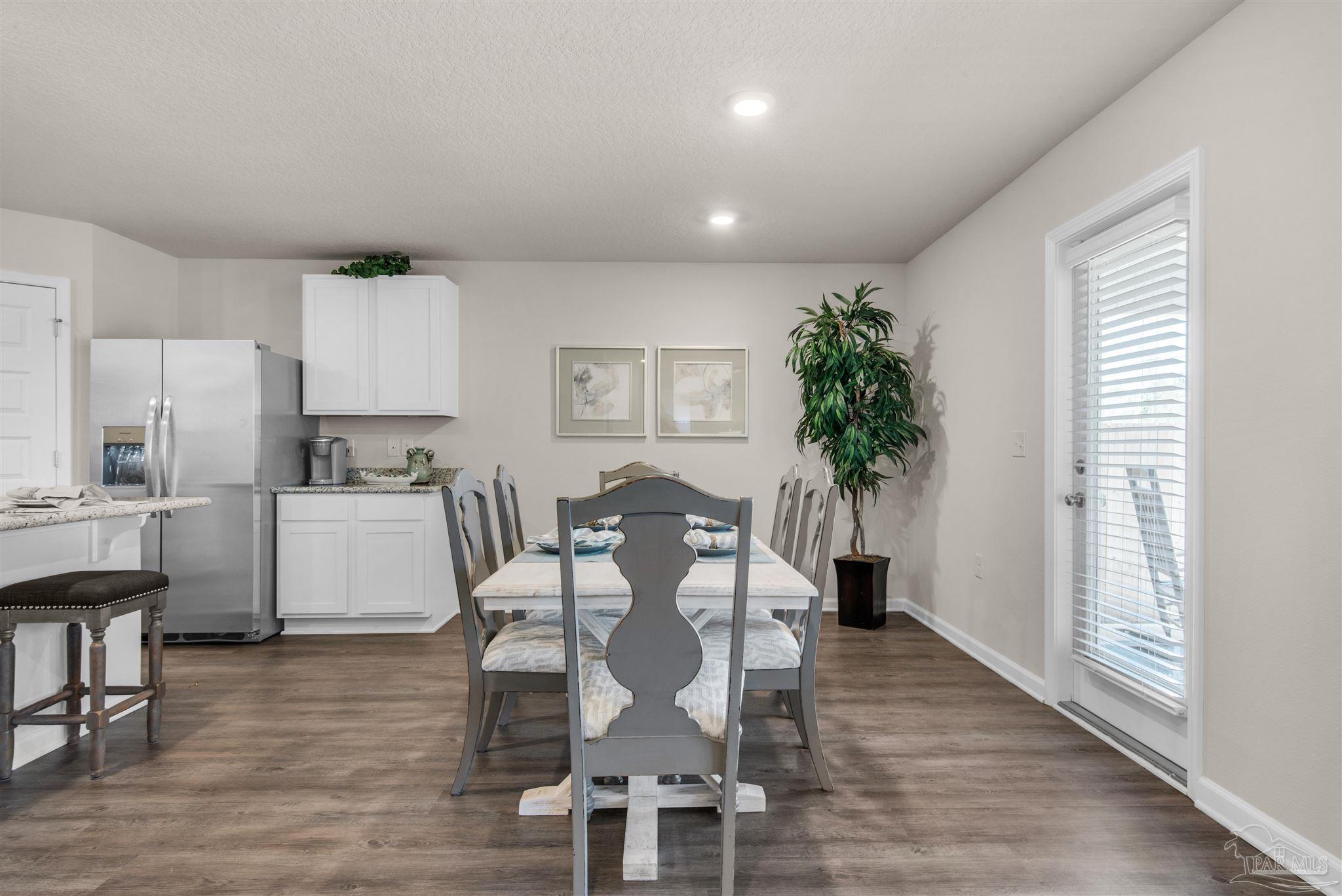 5213 Conservation Circle Pace, FL 32571 - Photo 4 of 13 a view of a dining room with furniture and wooden floor