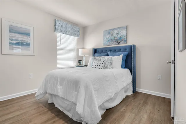 a large bed sitting in a bedroom next to a window